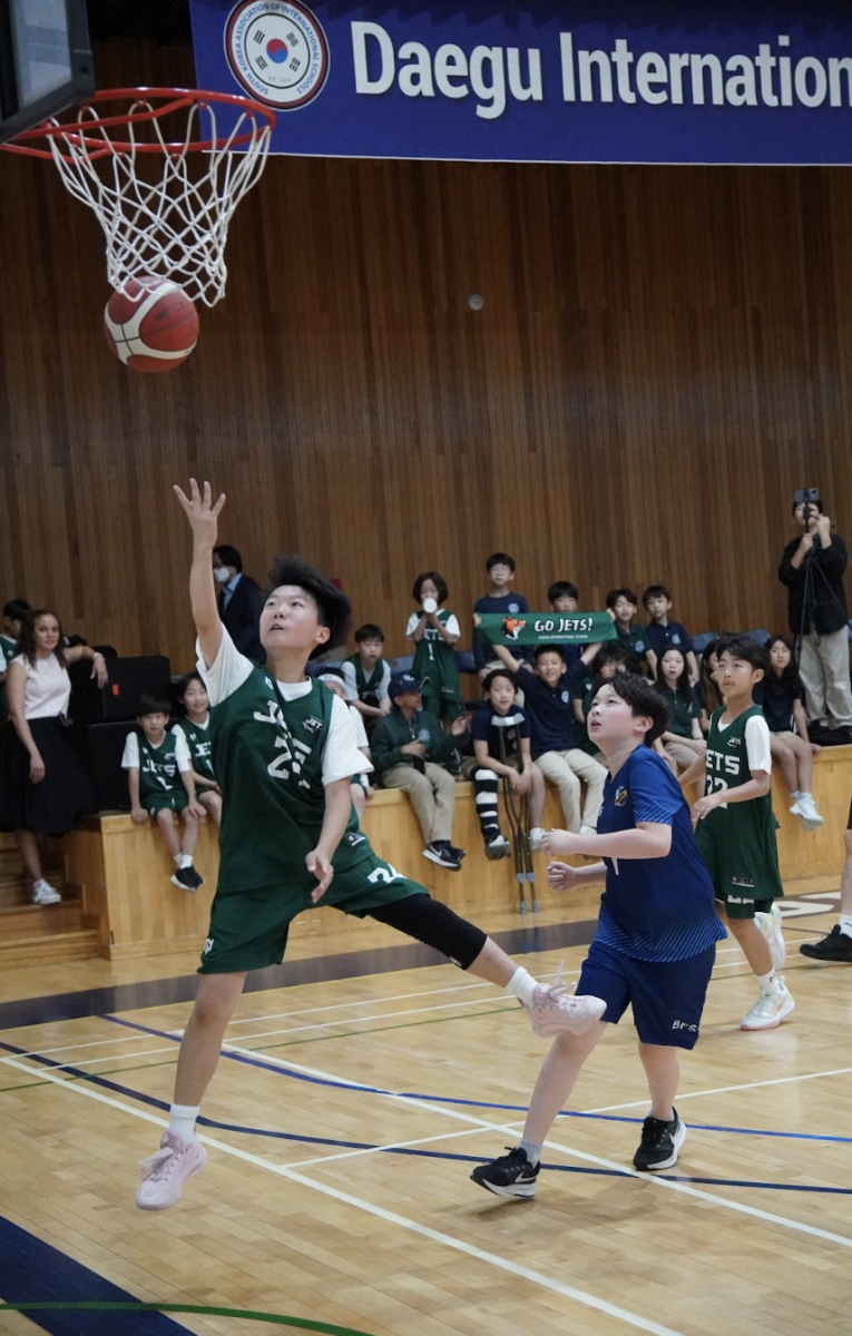 Fifth grader Joseph Cho channels the iconic Michael Jordan move as he drives to the hoop. Leaping high, he sinks a stylish basket, drawing cheers from the crowd.